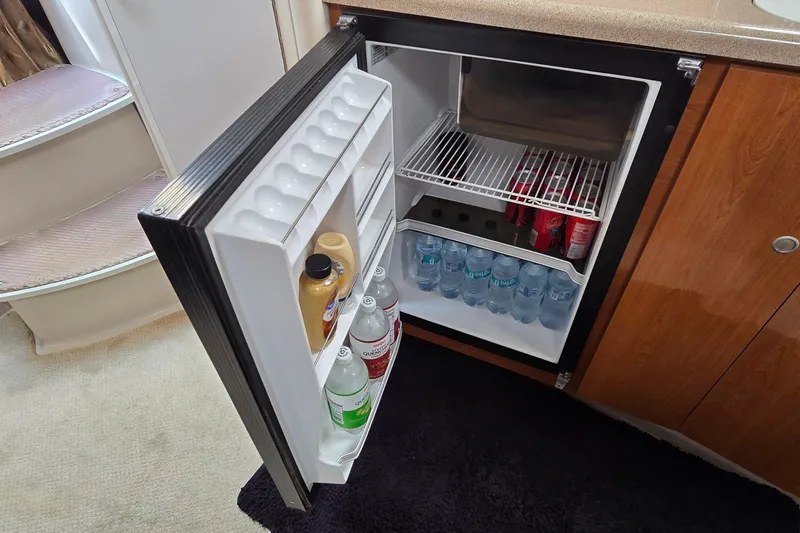 Slide: The Image of Mini fridge stocked with beverages inside a 2000 Four Winns 328 Vista boat cabin. - 22