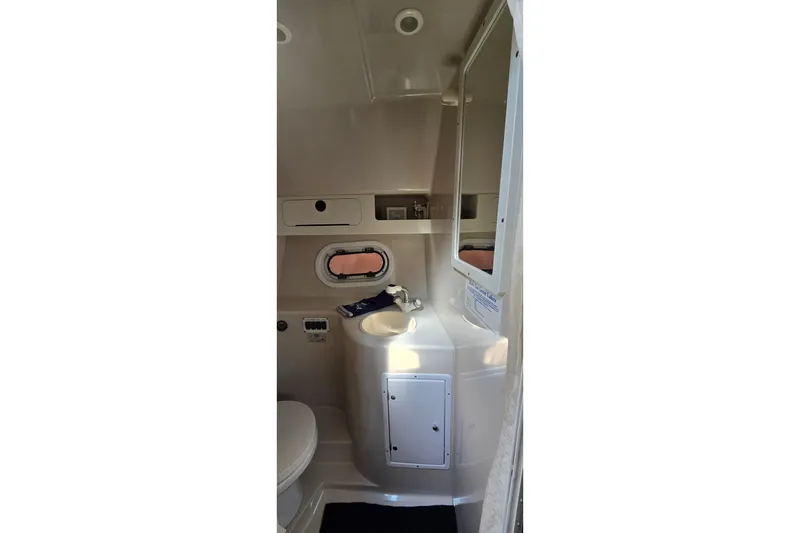 Slide: The Image of 2000 Four Winns 328 Vista boat bathroom with sink, mirror, and porthole window. - 26