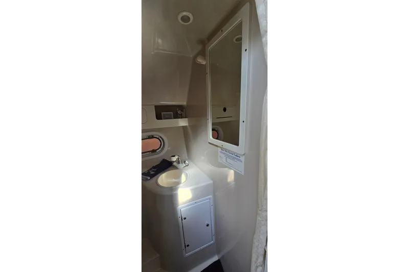 Slide: The Image of Compact bathroom in 2000 Four Winns 328 Vista boat, featuring sink and mirror. - 28