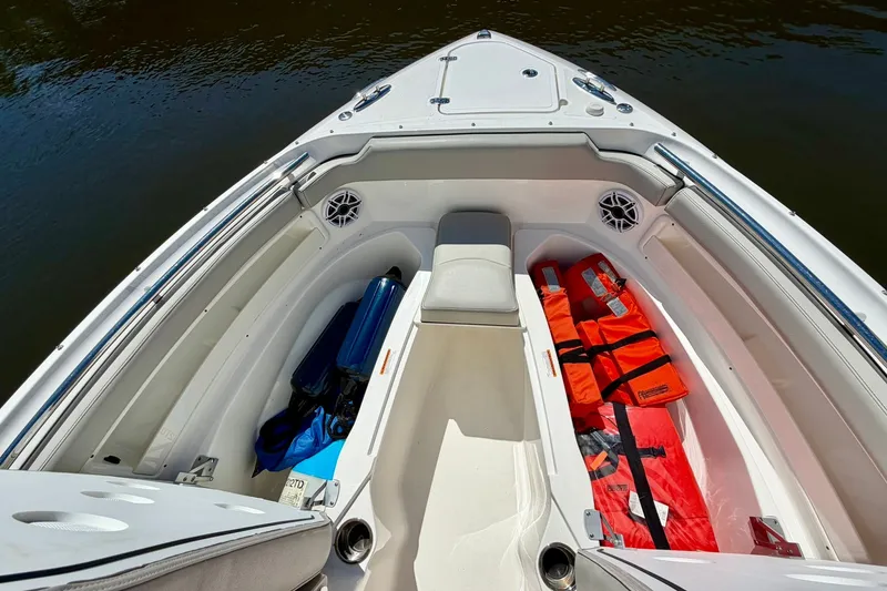Slide: The Image of 2022 Pursuit DC 266 Dual Console boat interior with life jackets and storage compartments. - 38