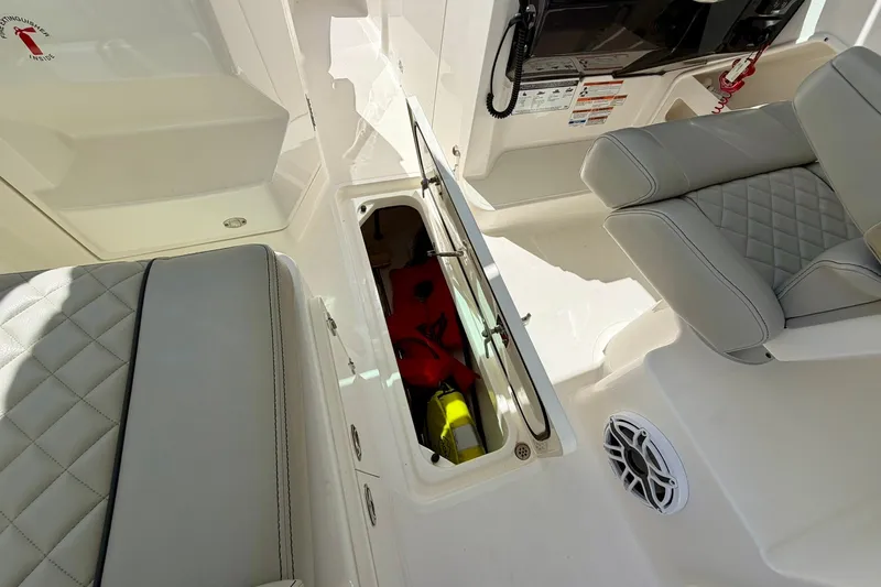 Slide: The Image of 2022 Pursuit DC 266 Dual Console interior with open storage compartment and cushioned seating. - 30