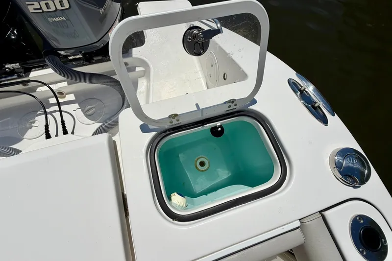 Slide: The Image of 2022 Pursuit DC 266 Dual Console boat with open storage compartment and Yamaha 200 engine. - 13