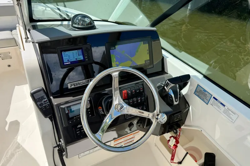 Slide: The Image of 2022 Pursuit DC 266 Dual Console boat dashboard with steering wheel and navigation controls. - 27