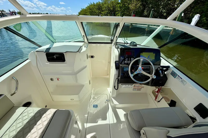 Slide: The Image of 2022 Pursuit DC 266 Dual Console boat interior with steering wheel and navigation system. - 23
