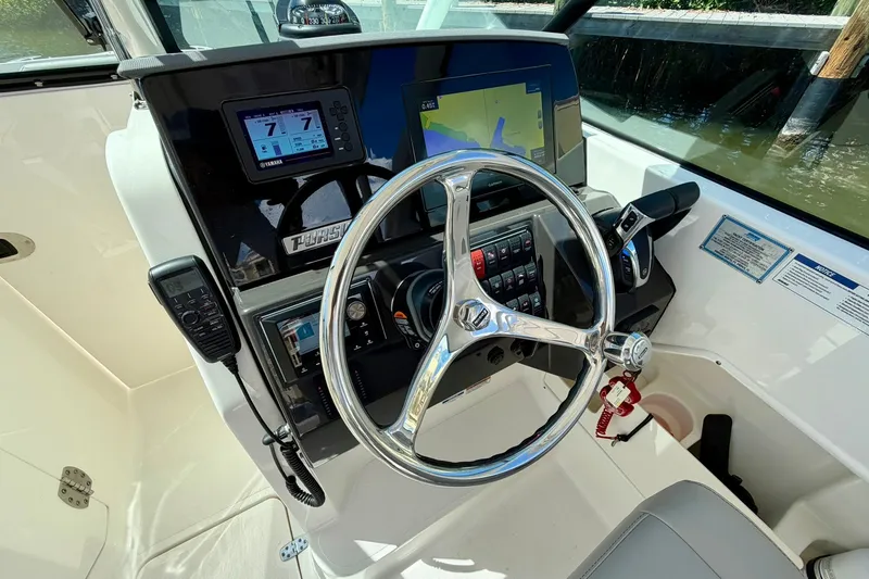 Slide: The Image of Steering console of 2022 Pursuit DC 266 Dual Console boat with modern controls and displays. - 26