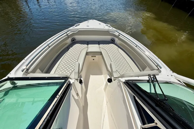 Slide: The Image of 2022 Pursuit DC 266 Dual Console boat with luxurious seating on calm water. - 37