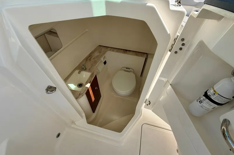 Slide: The Image of 2022 Pursuit DC 266 Dual Console boat interior with compact bathroom amenities. - 33