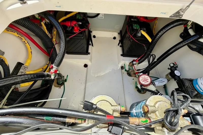 Slide: The Image of 2022 Pursuit DC 266 Dual Console boat engine compartment with batteries and wiring. - 18
