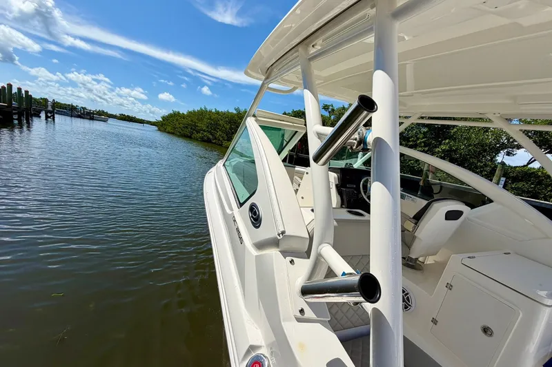 Slide: The Image of 2022 Pursuit DC 266 Dual Console boat on calm water under a clear blue sky. - 35