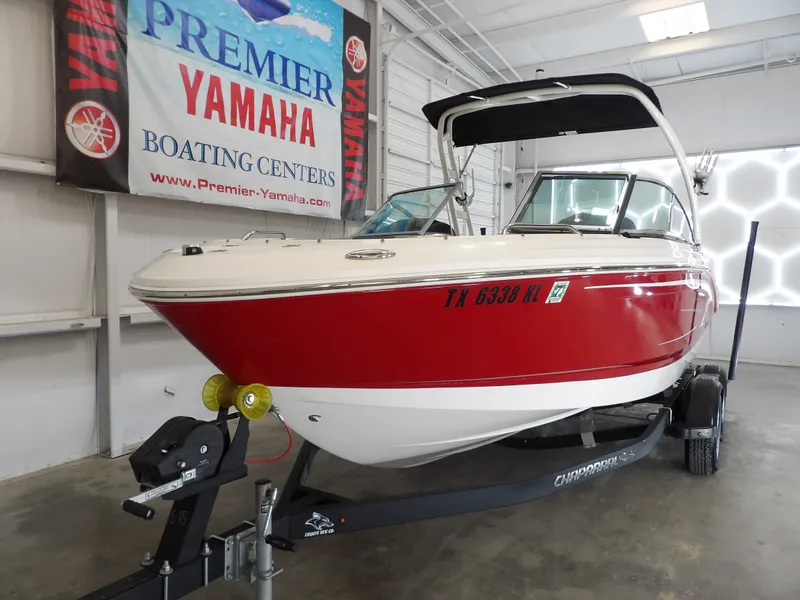 Slide: The Image of A red 2021 Chaparral 21 SSi boat on a trailer inside a showroom. - 6