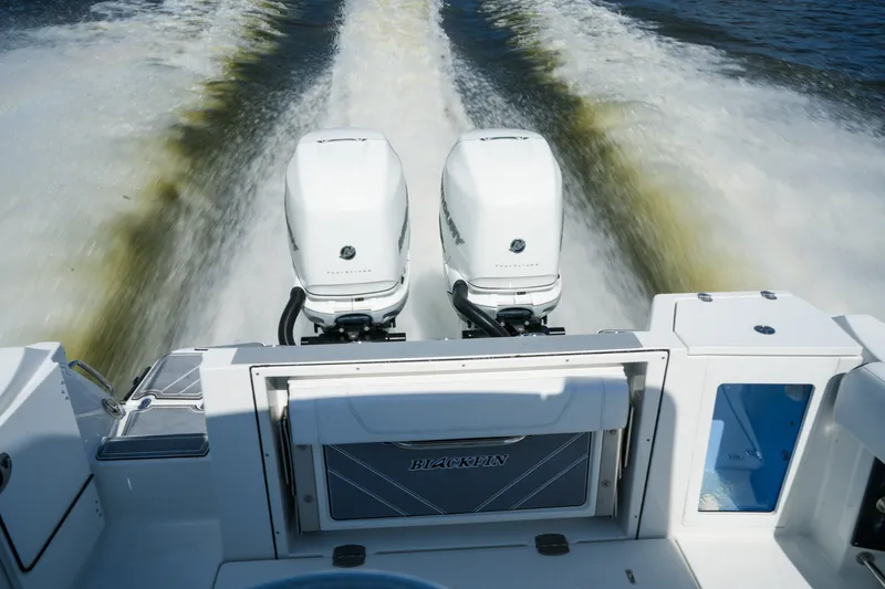 Slide: The Image of 2023 Blackfin 332 CC boat with dual outboard engines cruising on water. - 20