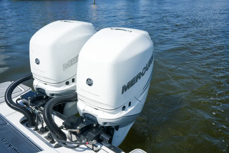 Slide: The Image of Twin Mercury outboard engines on a 2023 Blackfin 332 CC boat, docked on water. - 25