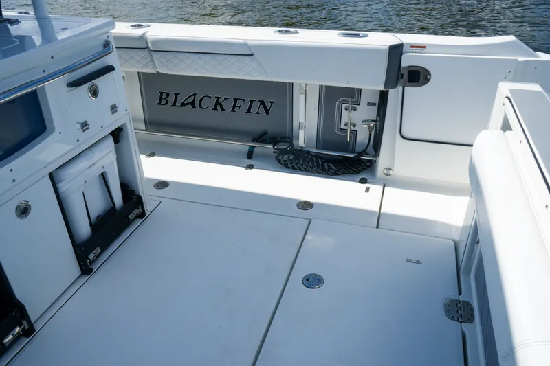 Slide: The Image of 2023 Blackfin 332 CC boat interior with storage and seating, on calm water. - 27