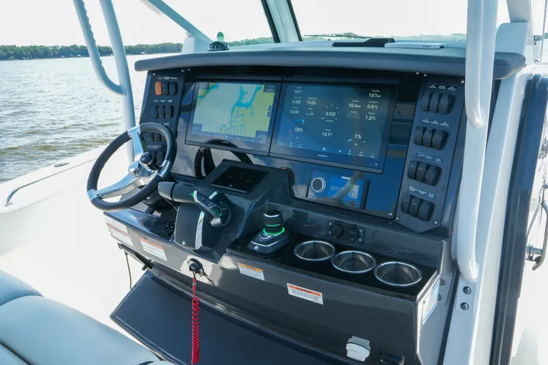 Slide: The Image of 2023 Blackfin 332 CC boat dashboard with navigation screens and controls on open water. - 17