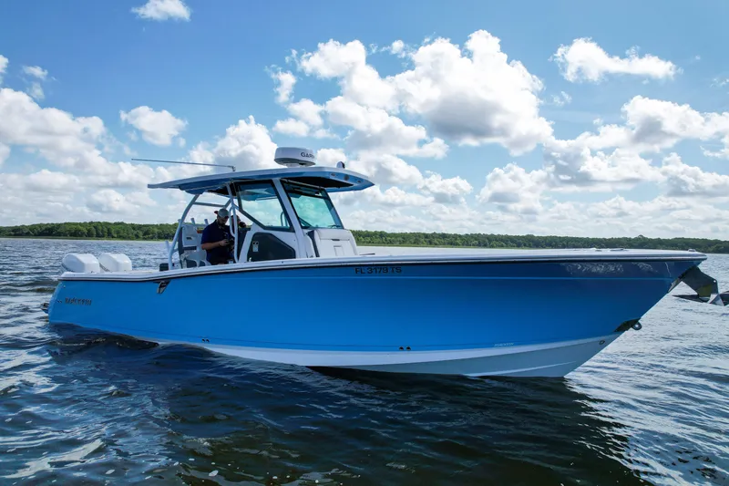 Slide: The Image of 2023 Blackfin 332 CC boat cruising on a sunny day with blue skies. - 23