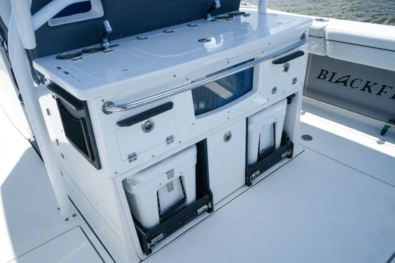 Slide: The Image of 2023 Blackfin 332 CC boat interior with storage compartments and coolers. - 12