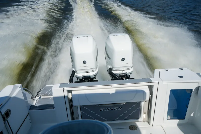 Slide: The Image of 2023 Blackfin 332 CC boat with dual outboard engines cruising on water. - 44