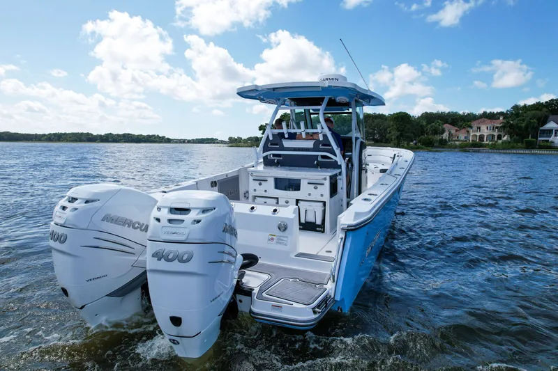 Slide: The Image of 2023 Blackfin 332 CC boat with twin Mercury 400 engines on a scenic lake. - 2