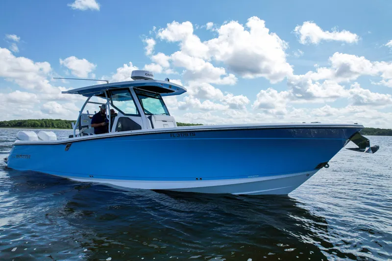 Slide: The Image of 2023 Blackfin 332 CC boat on water under blue sky with clouds. - 11