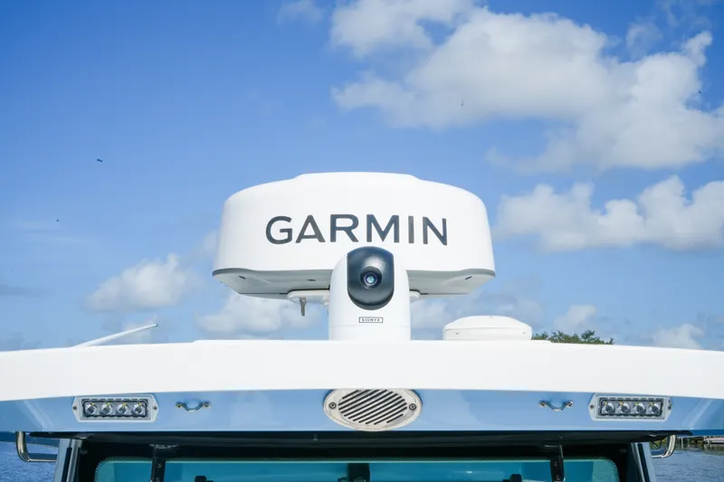 Slide: The Image of 2023 Blackfin 332 CC boat with Garmin radar against blue sky. - 14