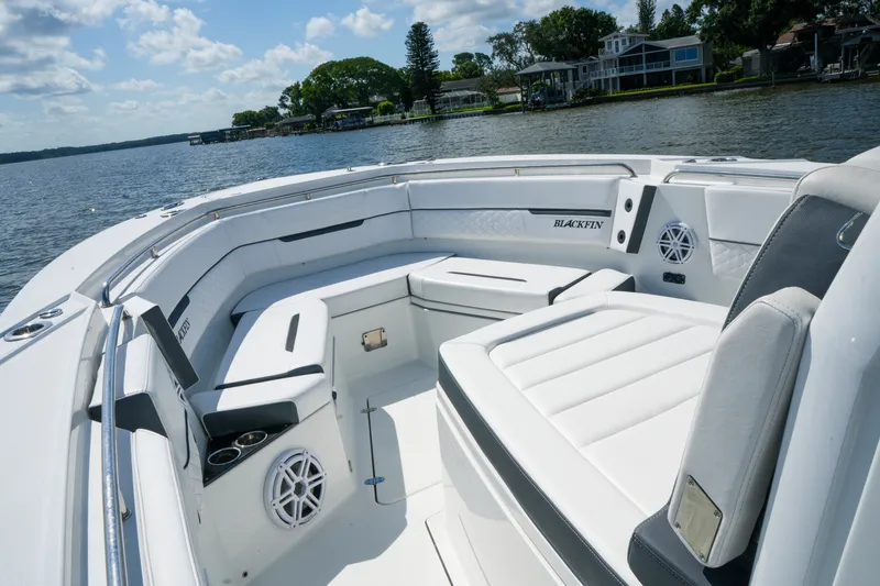 Slide: The Image of 2023 Blackfin 332 CC boat interior with white seating and scenic waterfront view. - 33