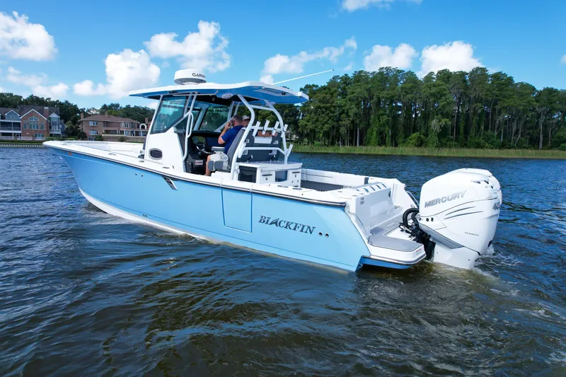 The Image of 2023 Blackfin 332 CC boat cruising on a lake with scenic background. - 5