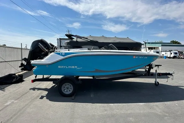 The Image of A blue and white 2024 Bayliner M17 sits on a trailer in an outdoor area. - 1