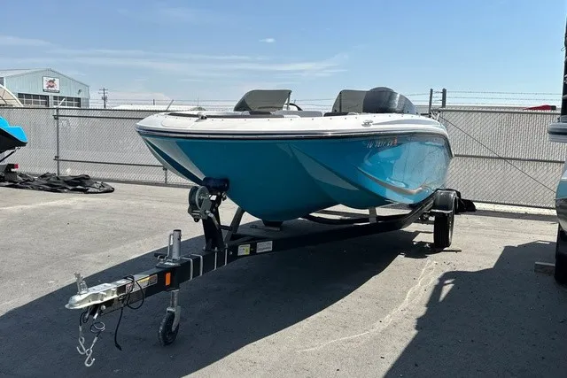 Slide: The Image of A blue 2024 Bayliner M17 boat on a trailer in a fenced area. - 7