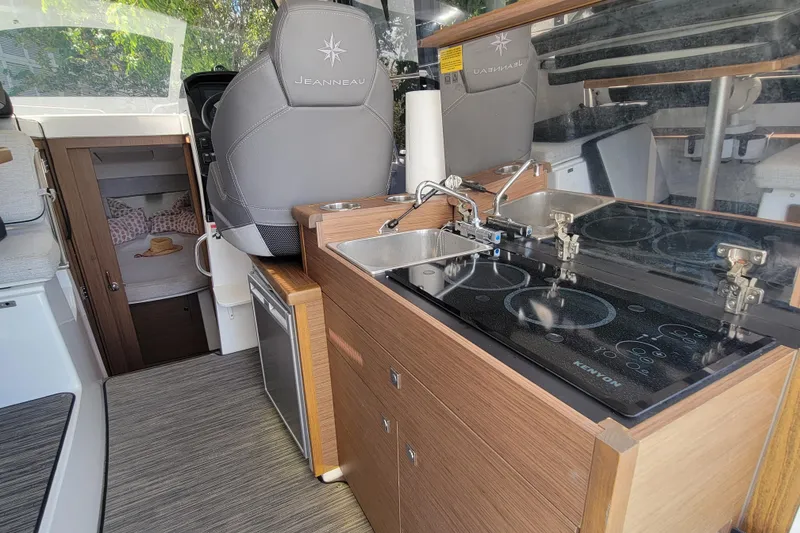 Slide: The Image of 2023 Jeanneau NC 895 interior with kitchenette and cozy cabin view. - 14