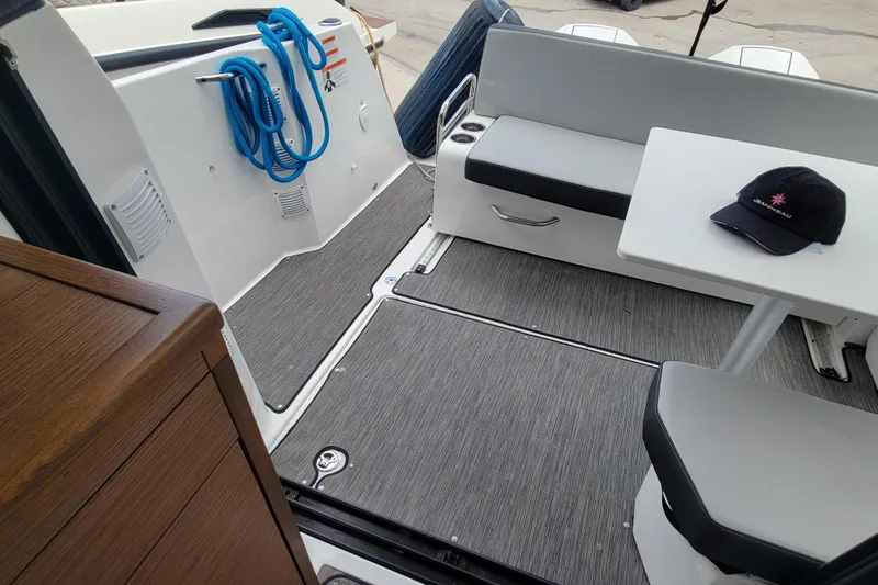 Slide: The Image of 2023 Jeanneau NC 895 boat interior with seating, table, and coiled blue rope. - 9