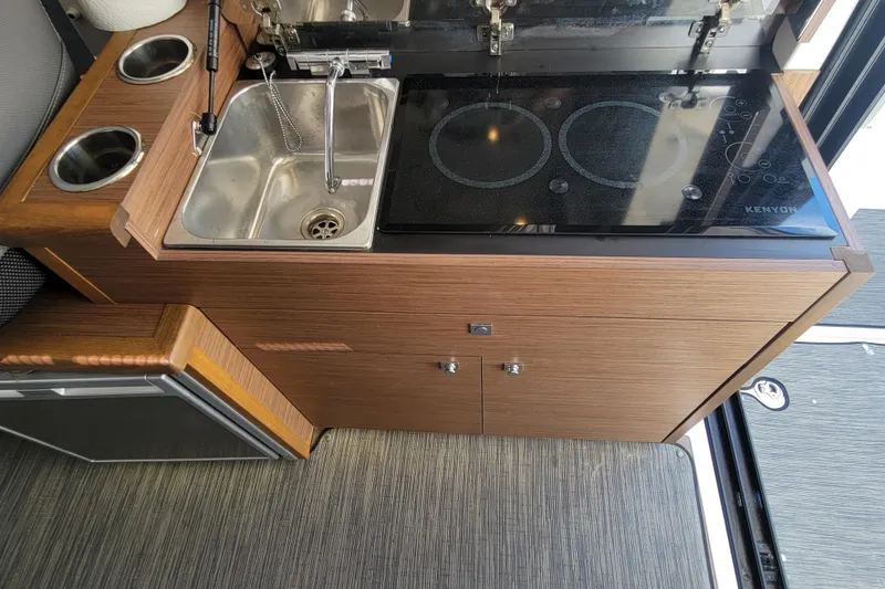 Slide: The Image of 2023 Jeanneau NC 895 kitchen area with sink and electric stove. - 16
