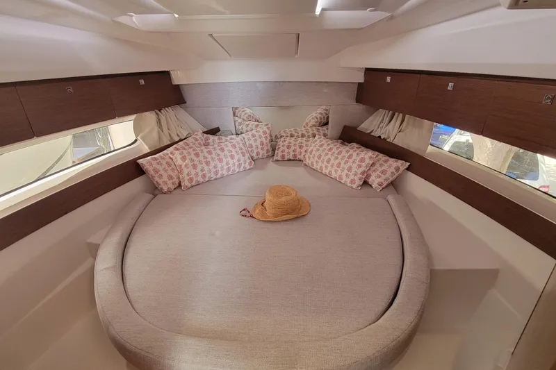 Slide: The Image of 2023 Jeanneau NC 895 cabin interior with cozy bed and decorative pillows. - 23