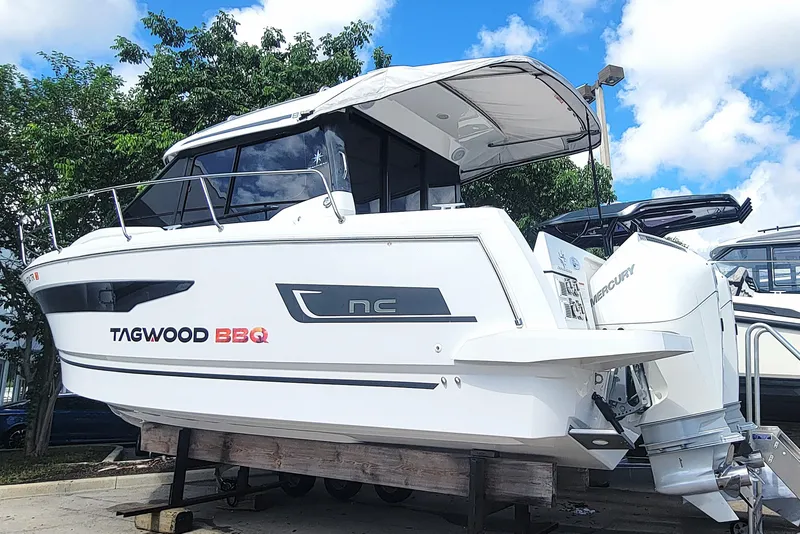 Slide: The Image of 2023 Jeanneau NC 895 boat with Mercury engine, displayed outdoors under a blue sky. - 4
