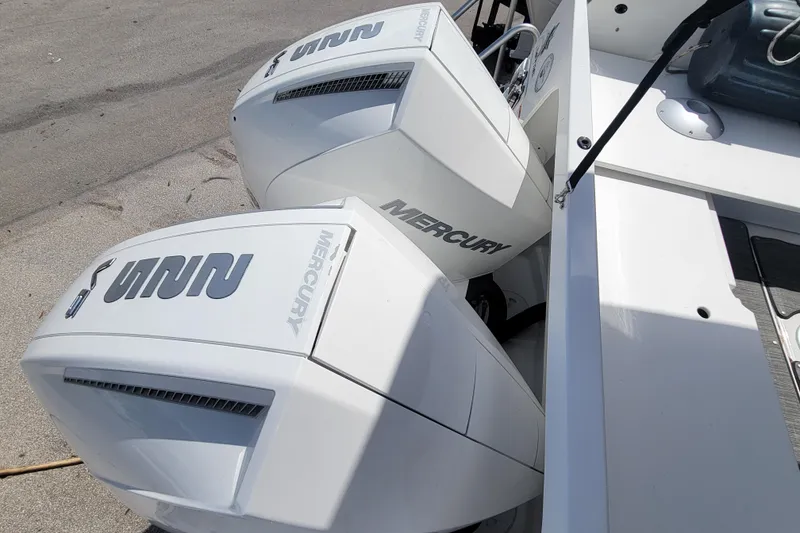 Slide: The Image of Twin Mercury outboard engines on a 2023 Jeanneau NC 895 boat, docked on concrete. - 6