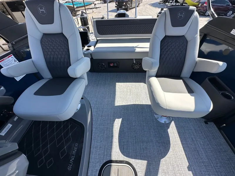 Slide: The Image of Two cushioned seats on a boat with gray carpet flooring and speakers in the background. - 32