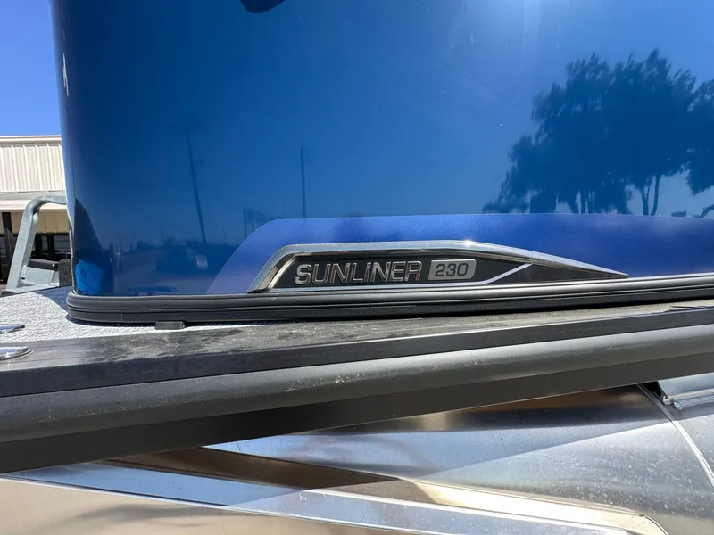 Slide: The Image of Close-up of the Harris Sunliner 230 with a blue hull and model badge. - 37