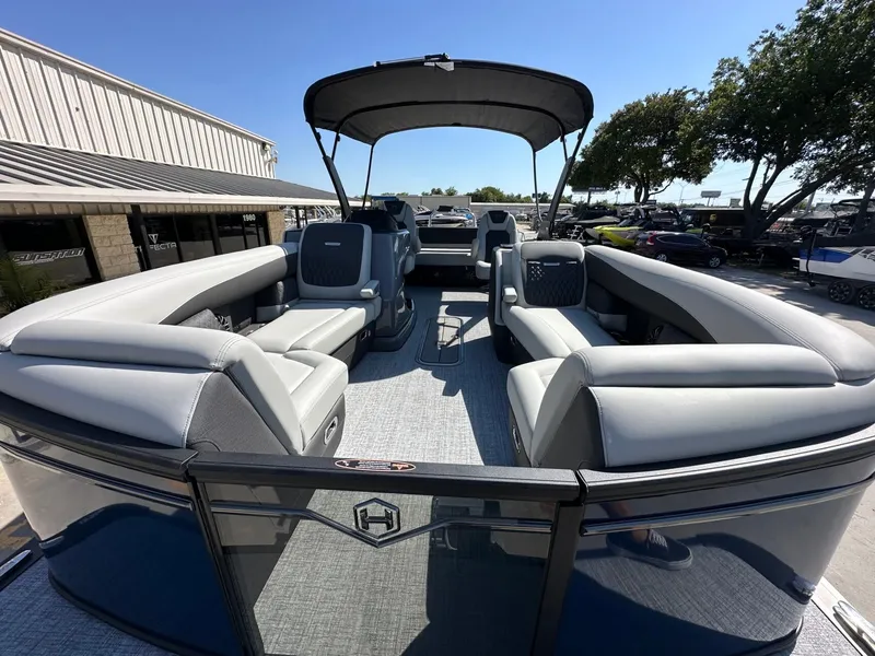 Slide: The Image of The image shows a Harris Sunliner 230 pontoon boat with gray upholstery and a sunshade. - 30