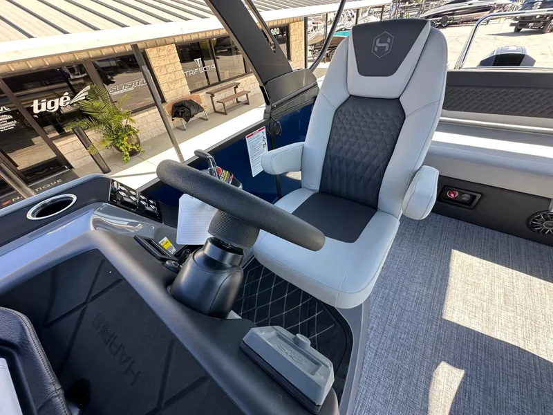 Slide: The Image of The image shows the helm of a 2027 Harris Sunliner 230 with a cushioned captain's chair. - 31