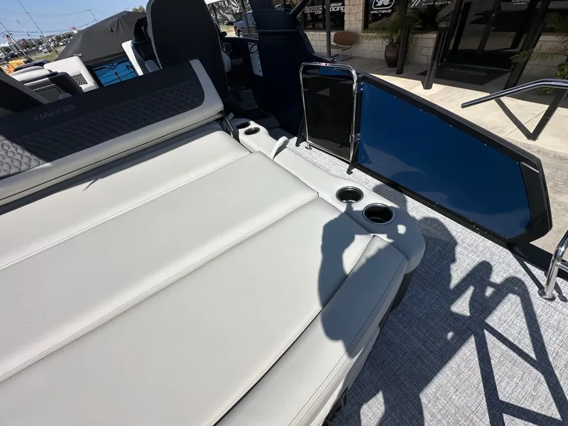 Slide: The Image of The image shows the deck of a 2027 Harris Sunliner 230 with beige upholstery and cup holders. - 15