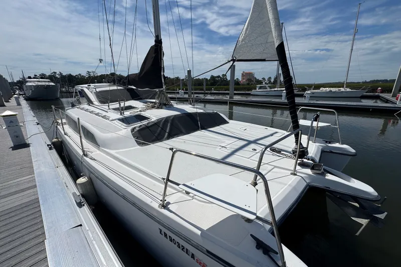 Slide: The Image of 2007 Gemini 105 MC catamaran docked at a marina under a clear blue sky. - 5