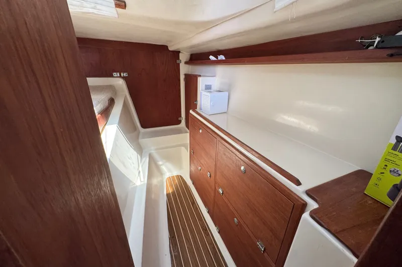 Slide: The Image of Interior of 2007 Gemini 105 MC sailboat with wooden cabinetry and compact storage space. - 21