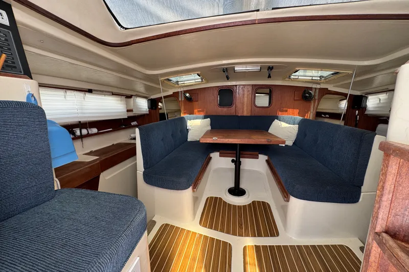 Slide: The Image of Interior of a 2007 Gemini 105 MC sailboat with blue seating and wooden accents. - 12