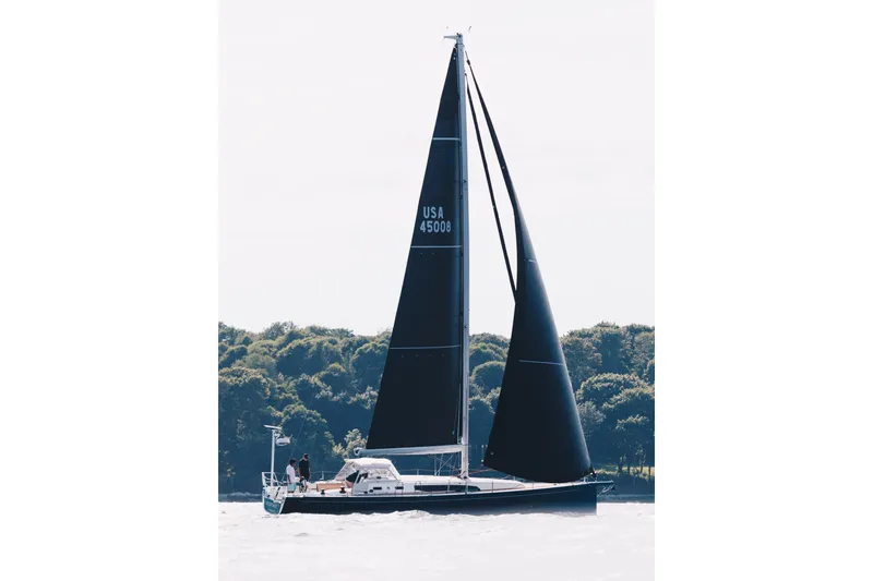 Slide: The Image of 2024 J Boats J/45 sailing yacht with black sails on open water. - 4