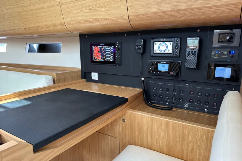 Slide: The Image of 2024 J Boats J/45 interior navigation station with modern control panels and wooden finish. - 13