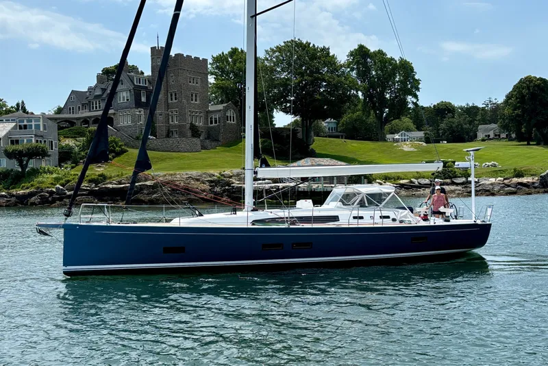 Slide: The Image of 2024 J Boats J/45 sailing near a picturesque shoreline with elegant architecture. - 1