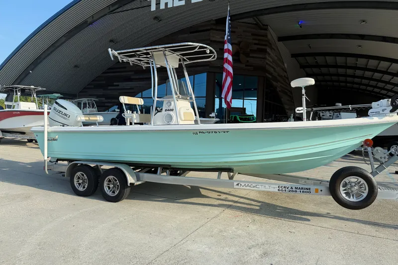Slide: The Image of 2020 Bulls Bay 2400 XS boat on trailer, displayed outdoors with American flag. - 2