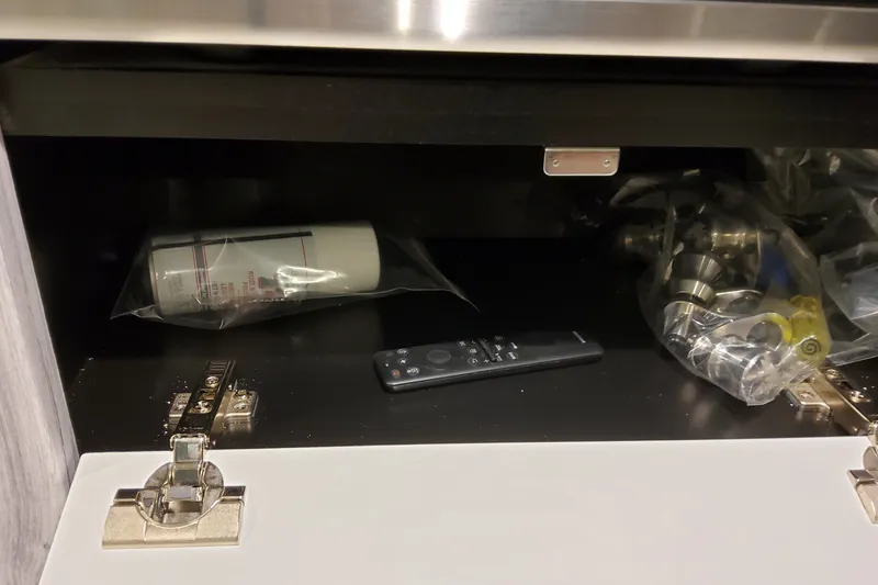 Slide: The Image of Cabinet interior with remote, spray can, and hardware in a Formula 400 Super Sport Crossover. - 29