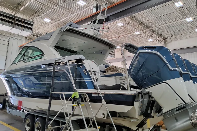 Slide: The Image of 2027 Formula 400 Super Sport Crossover boat in a warehouse, featuring powerful Mercury engines. - 6