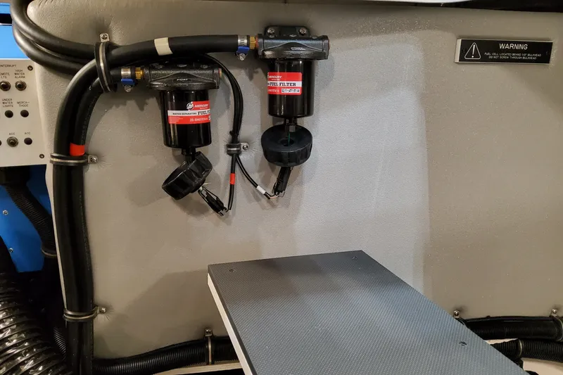 Slide: The Image of Engine compartment of 2027 Formula 400 Super Sport Crossover with fuel filters and warning label. - 52