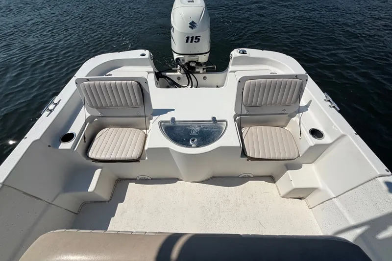 Slide: The Image of 2015 Carolina Skiff 218 DLV boat interior with seating and outboard motor on water. - 8